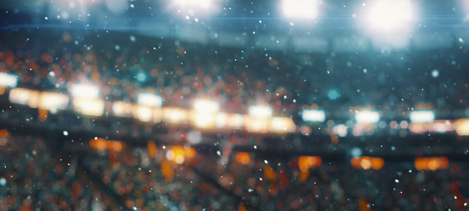 Blurry image of a football game during a snow storm.