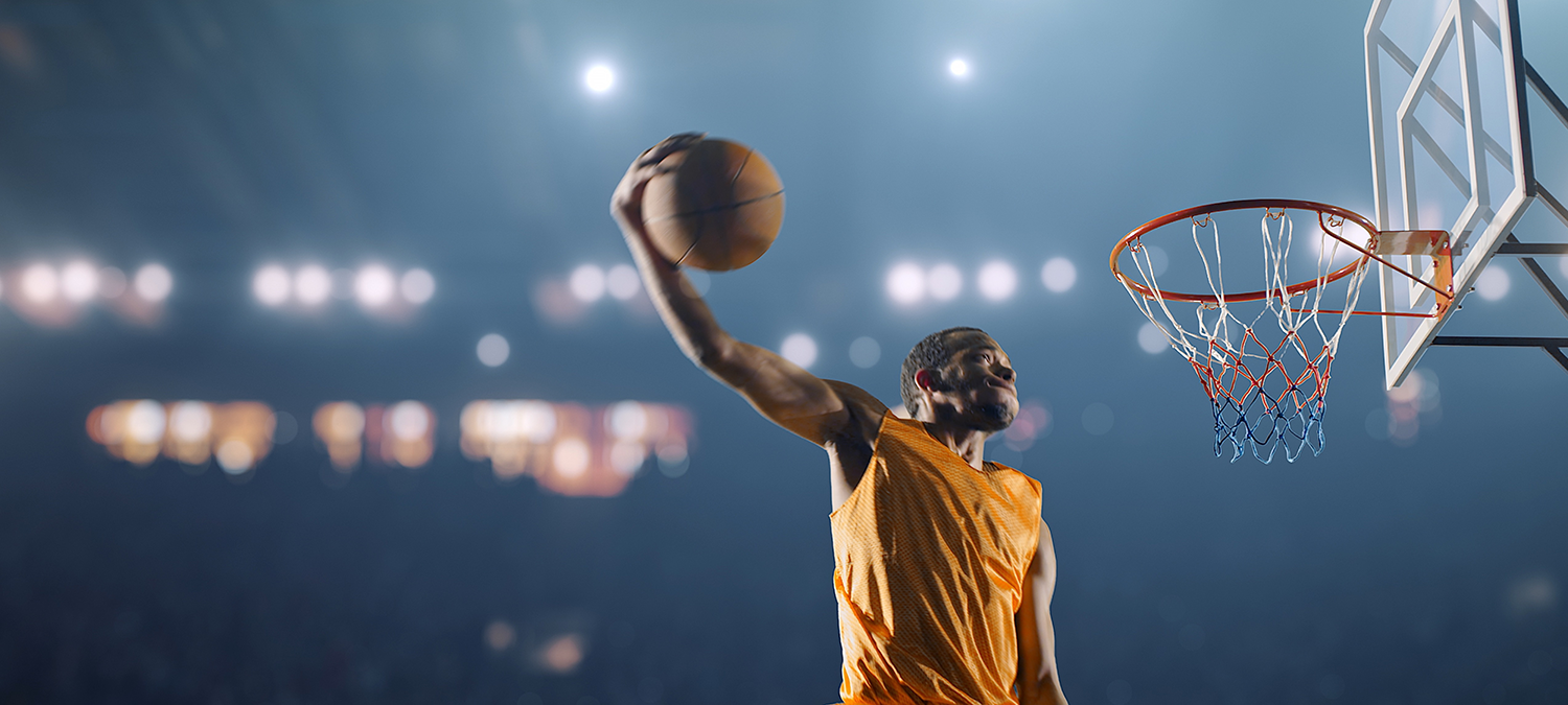 College basketball player making a slam dunk