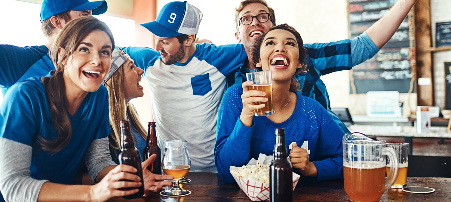 Fans at a local sports bar celebrating while watching a game