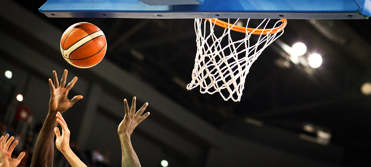 College basketball players jostling by the net
